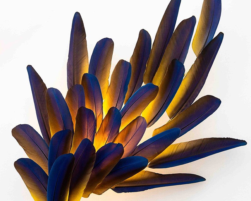 Illuminated feather wall sconce with deep blue & gold hues & ethereal textures by Janaïna Milheiro available through RUNE, New York.
