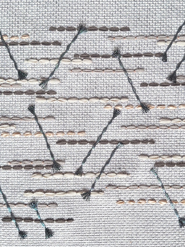 Close-up of geometric hand-stitched embroidery on beautifully textured fabric textile by P+L Studio, showcasing intricate French craftsmanship.